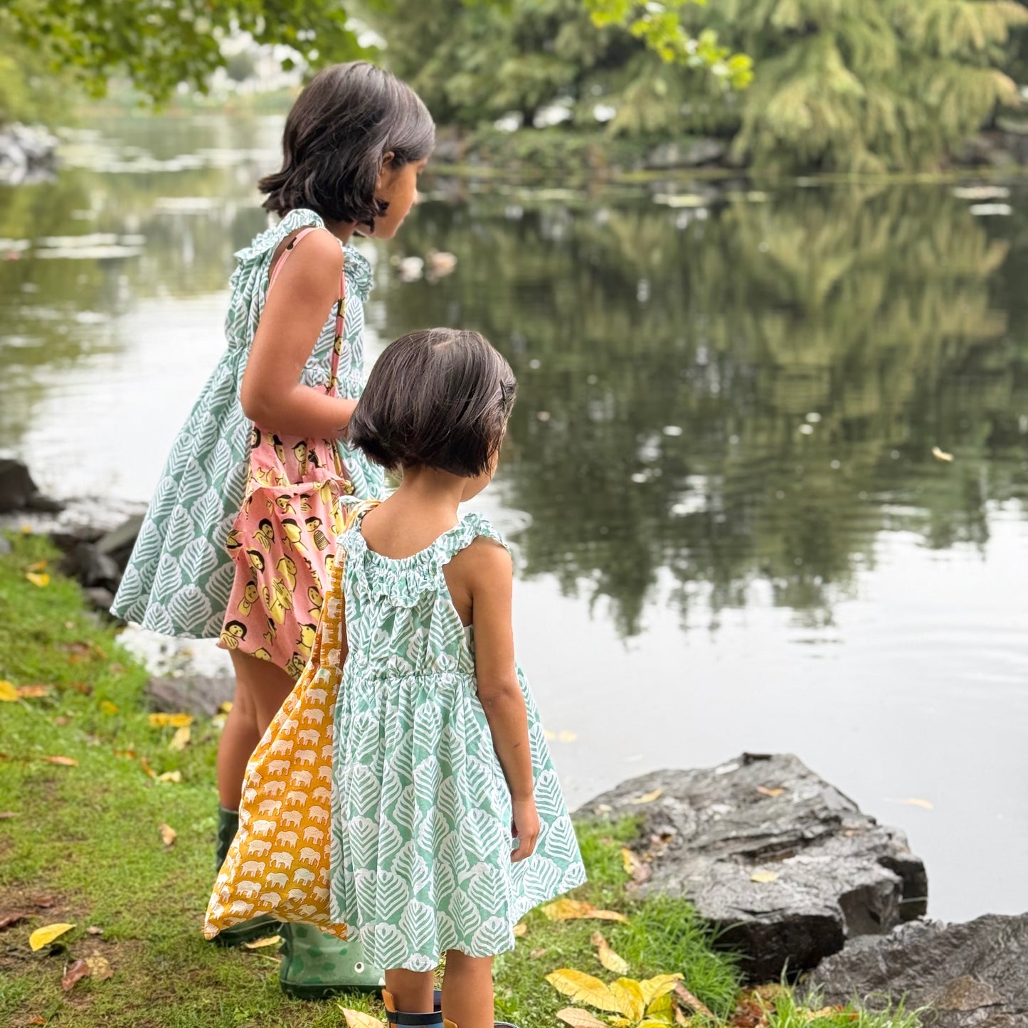 Sisters wearing coordinated cotton summer dresses