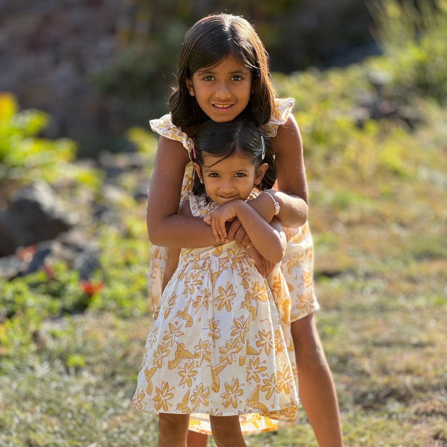 Two sisters wearing pastel floral cotton dress