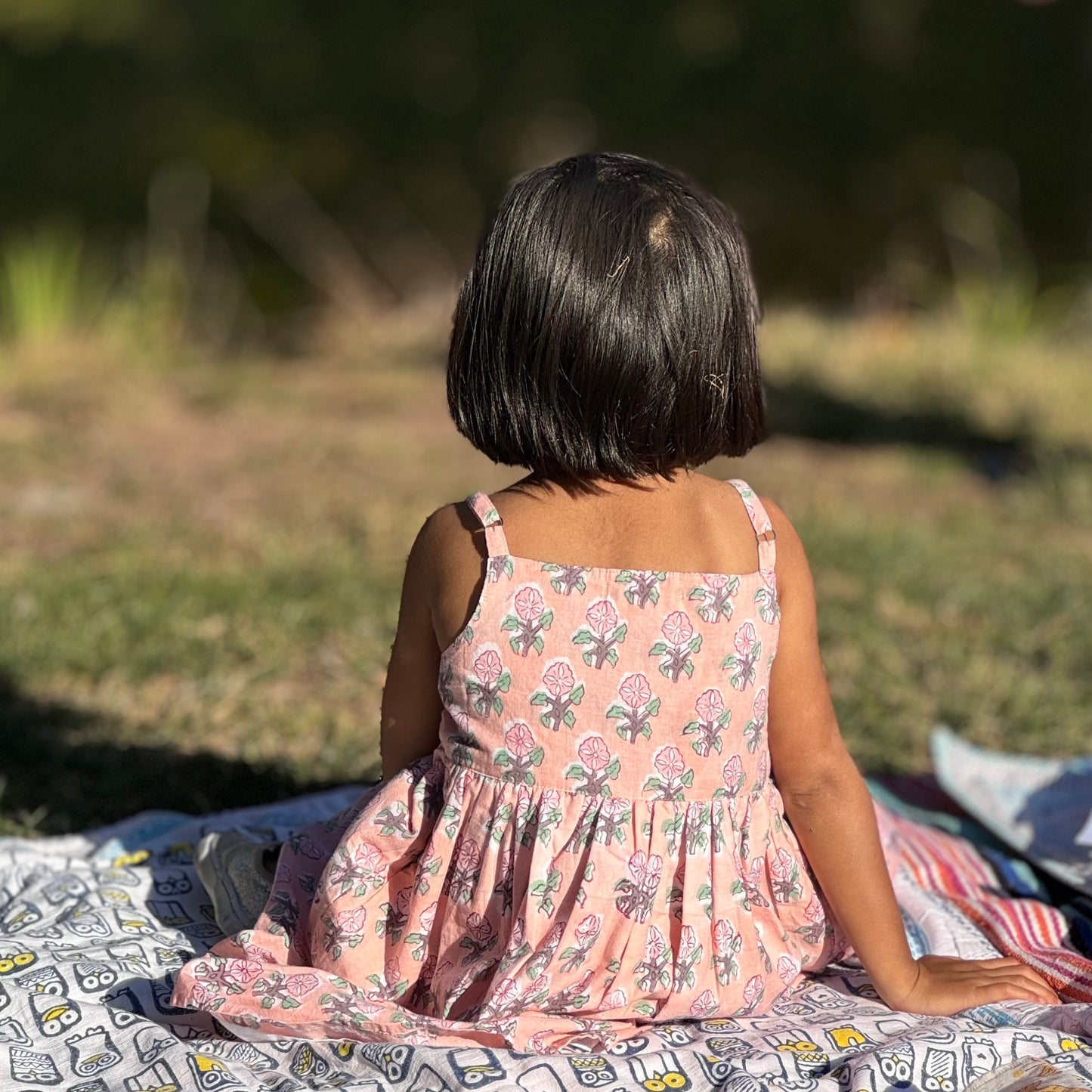 Girl sitting in Pink floral summer cotton dress