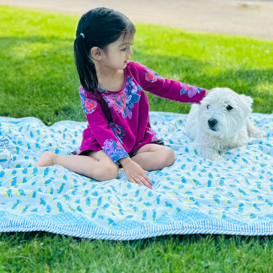 Toddler girl sitting on a cotton animal printed blanket
