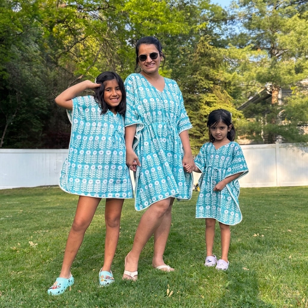 Mother and two daughters wearing matching organic cotton beach cover ups 